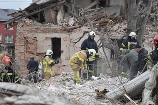 Rescuers search for victims in the debris of a destroyed house following a Russian rocket strike on the outskirts of Lviv